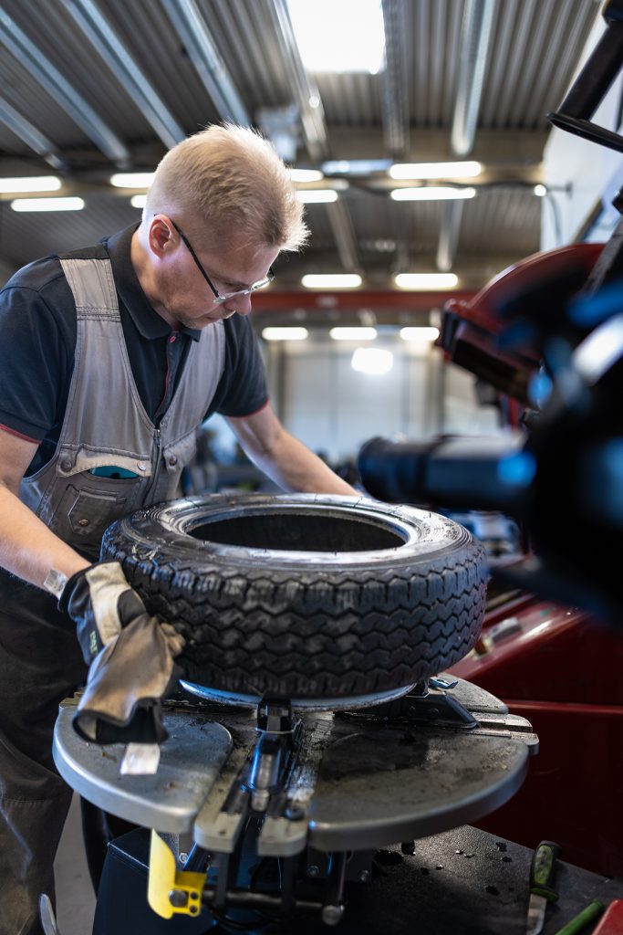 Asentaja vaihtaa autoon rengasta 