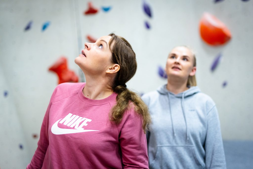 Wasa Up on antanut tehtävän ryhmälle, johon kaksi ryhmän jäsentä miettii ratkaisua ja katsovat ylöspäin kiipeilyseinän vieressä