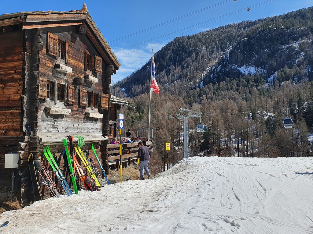 Laskettelumäen vieressä sijaitsee alppitalo, jonka seinustaan nojaa monta paria laskettelusuksia
