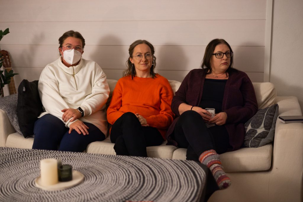 Lukupiiriin kuuluvat kolme naista istuvat sohvalla